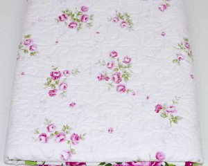 Cerise patchwork cot quilt folded showing centre front panel
