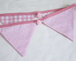 Baby pink bunting with pink pom-poms showing reverse