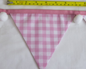 Baby pink bunting with white pom-poms flag width