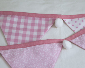 Baby pink bunting with whit pom-poms showing reverse