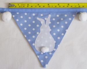Bunny bunting in blue with white pom-poms flag width