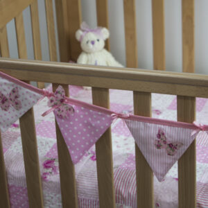 Flutterby Butterfly bunting in pink on cot with Flutterby Butterfly quilt