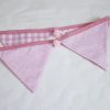 Baby pink bunting with pink pom-poms showing reverse
