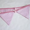 Baby pink bunting with pink pom-poms showing reverse
